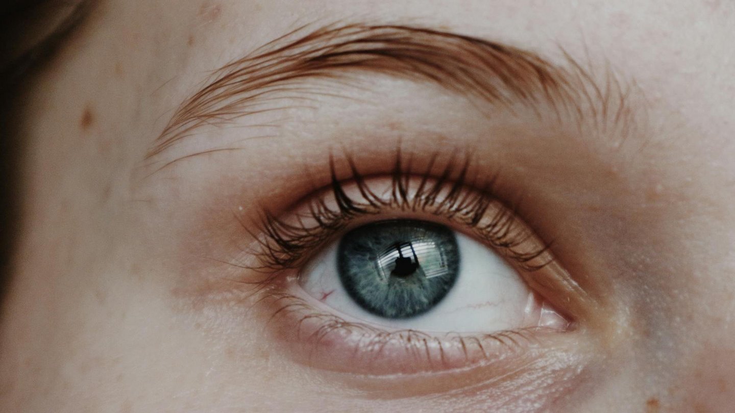 Detailaufnahme eines menschlichen Auges, das die feinen Details der Iris und die Textur der Wimpern zeigt.