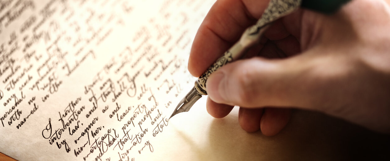 Eine Hand, die einen Federstift hält.