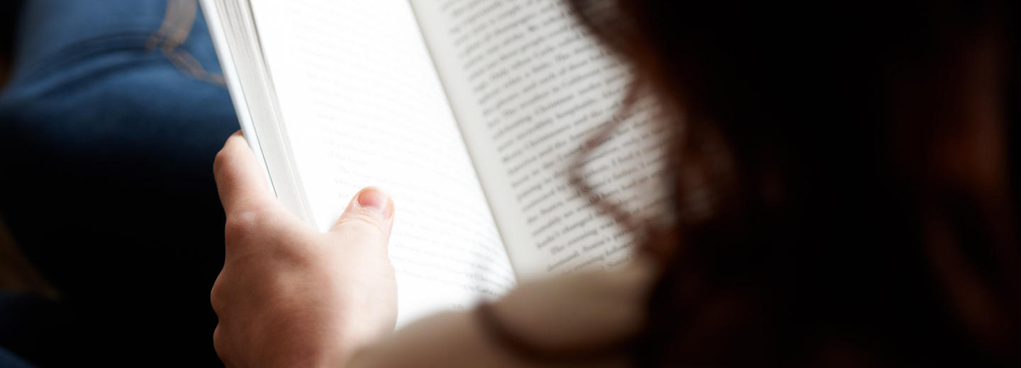 Eine Frau, die ein Buch hält.