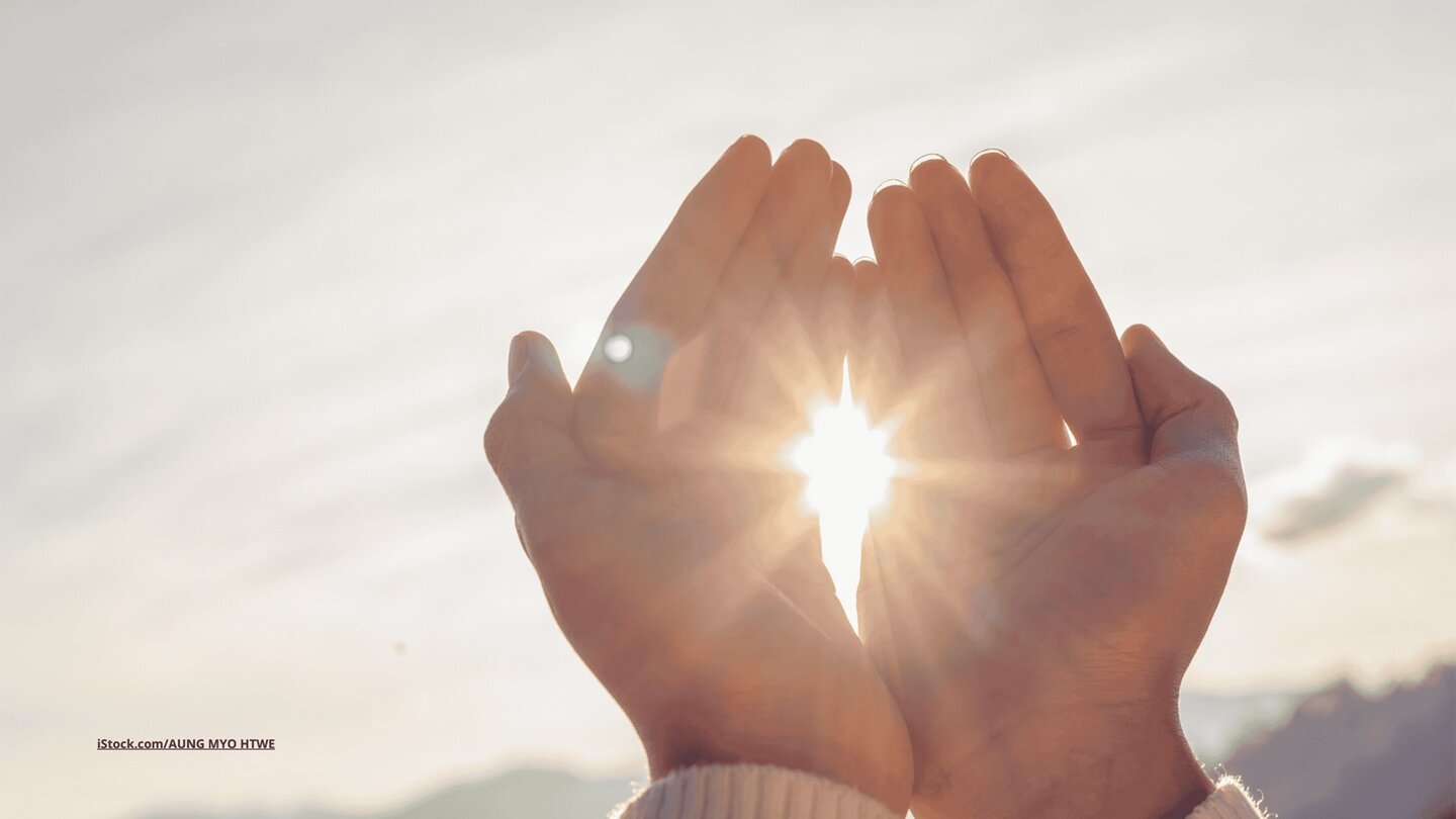 Das Foto zeigt Frauenhände vor der strahlenden Sonne.