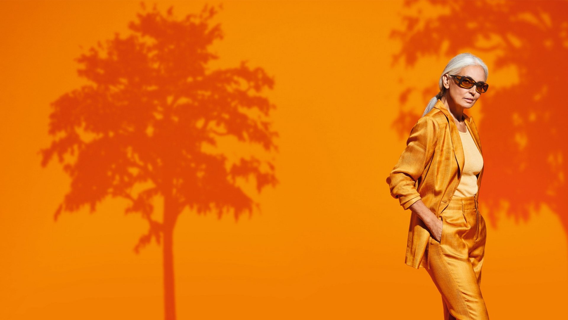 Das Bild zeigt eine orange gekleidete Frau mit einer ambelis Filterbrille. 