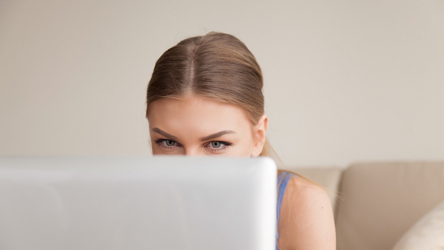 Das Foto zeigt eine Frau, die vor einem Computerbildschirm sitzt.