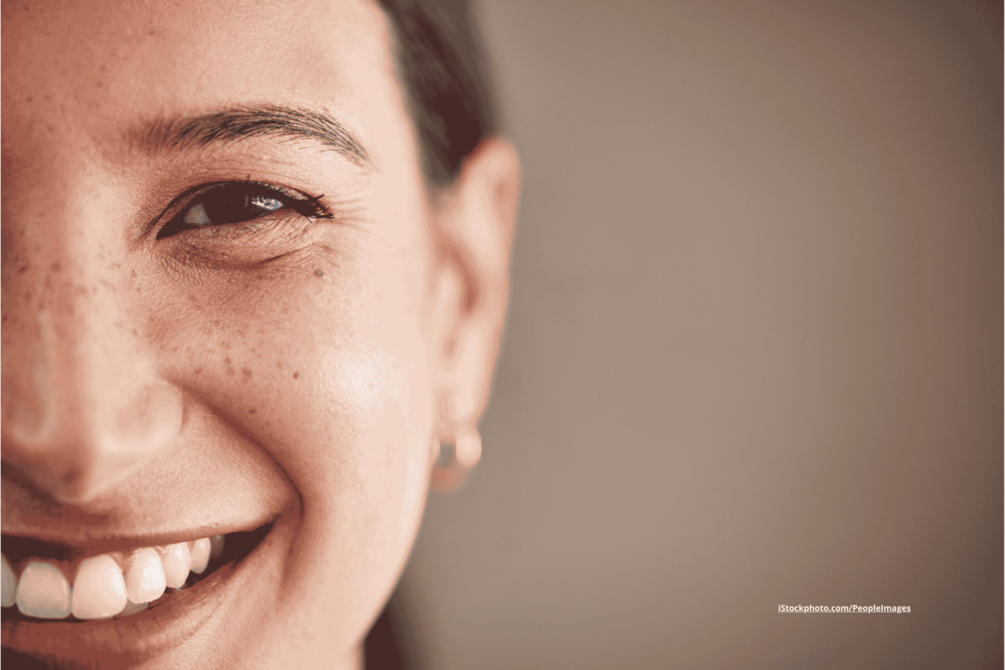 Das Foto zeigt die Gesichtshälfte einer lächelnden Frau.