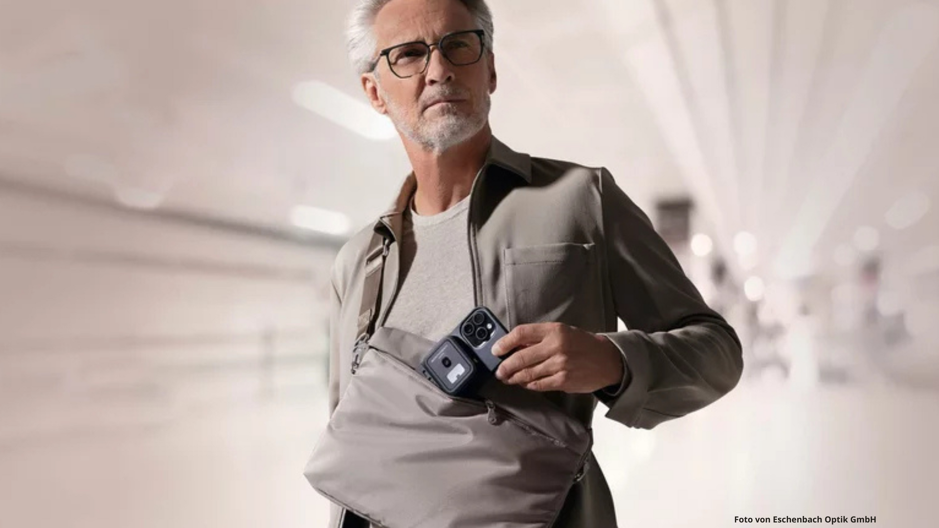 Ein Mann zieht sein optaro aus der Tasche. 