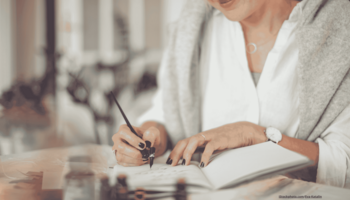 Junge Frau schreibt in einen persönlichen Organizer