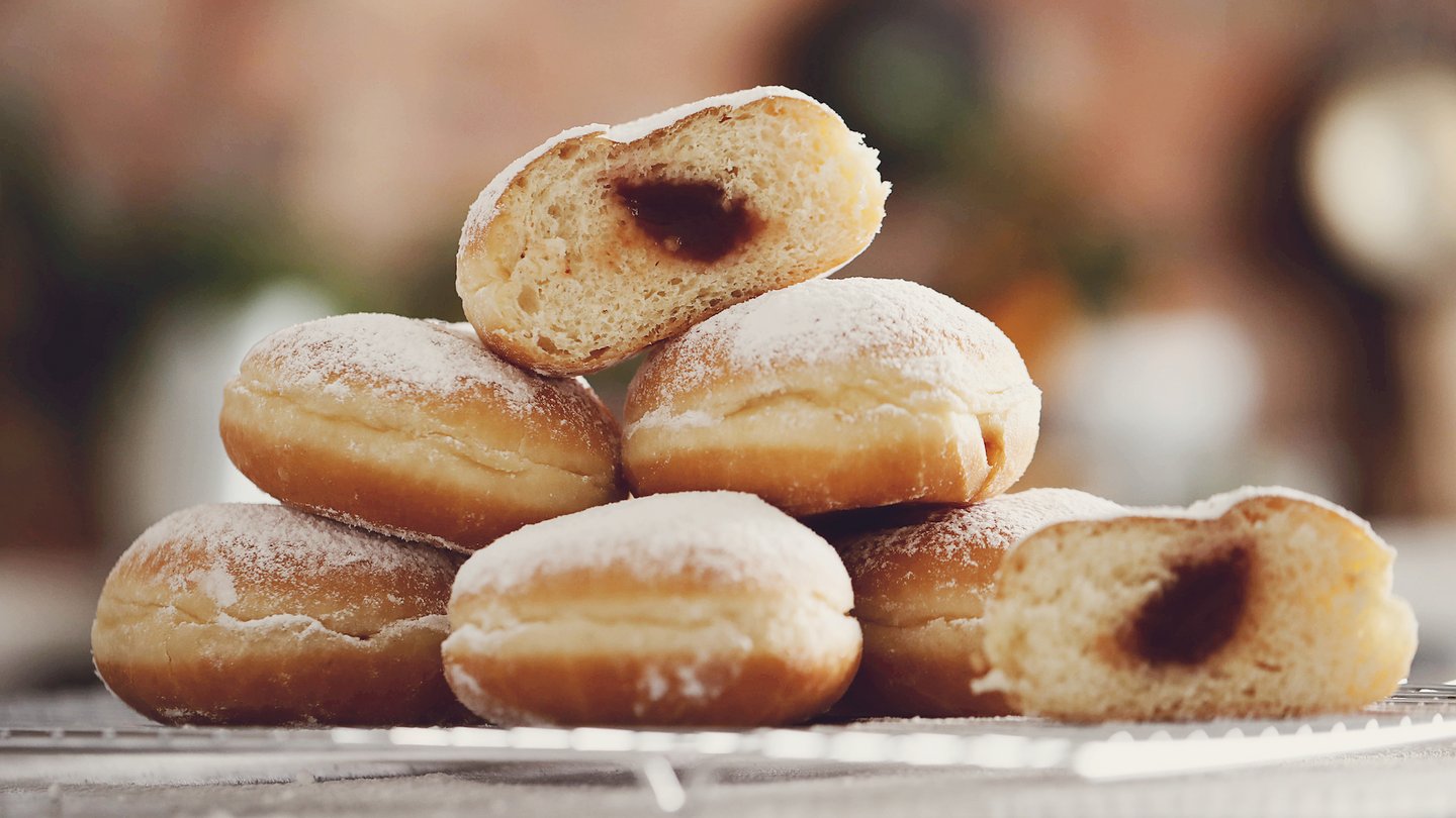 Das Foto zeigt Berliner Pfannkuchen auf einem Abtropfgitter.