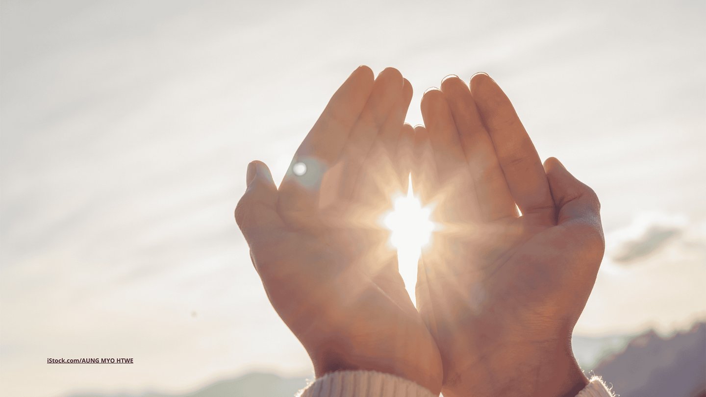Das Foto zeigt Frauenhände vor der strahlenden Sonne.