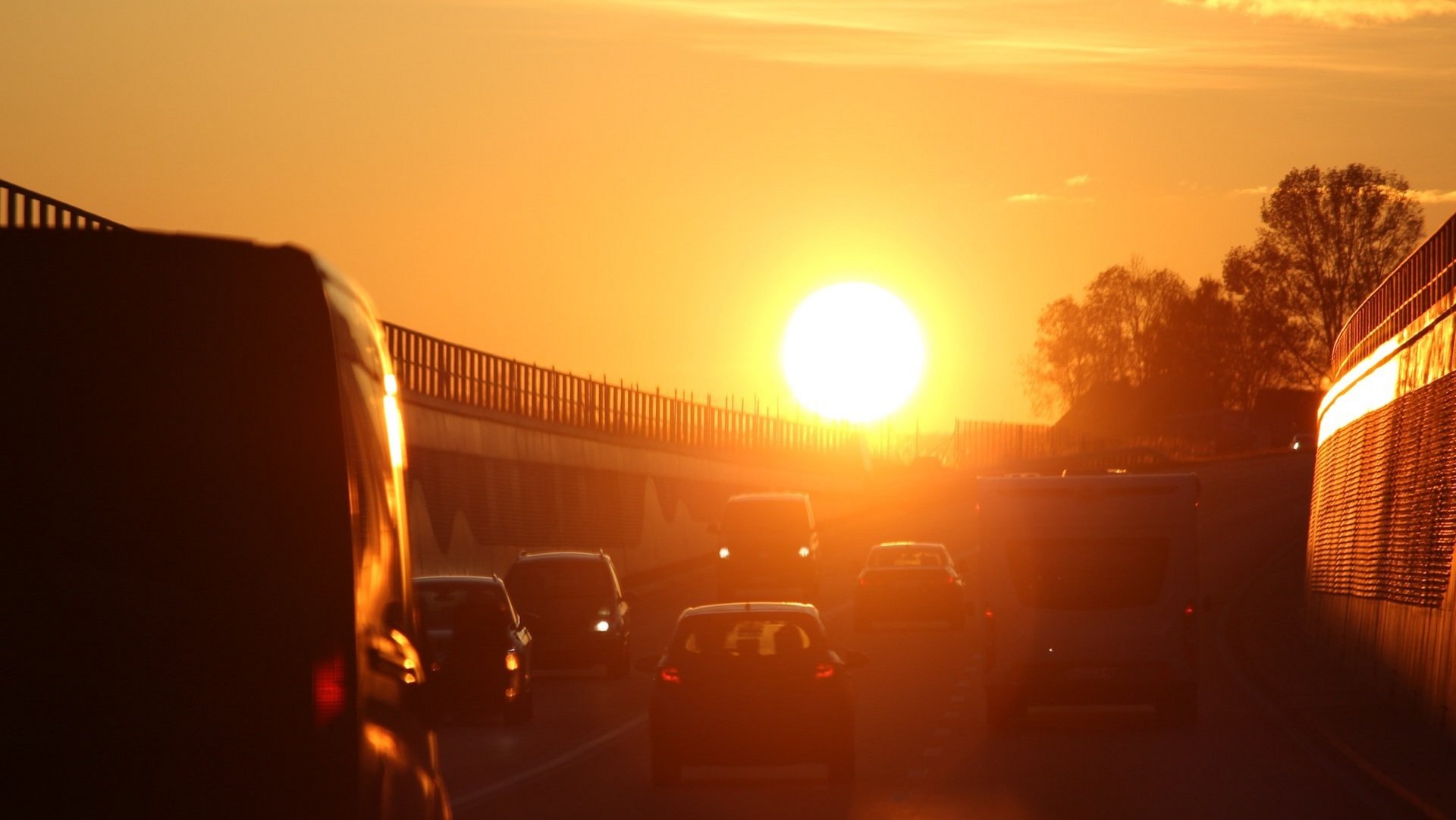 Das Bild zeigt Autos auf einer Autobahn bei sonnigem Herbstwetter.