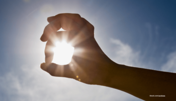 Das Bild zeigt eine Hand durch die Sonnenstrahlen zu sehen sind