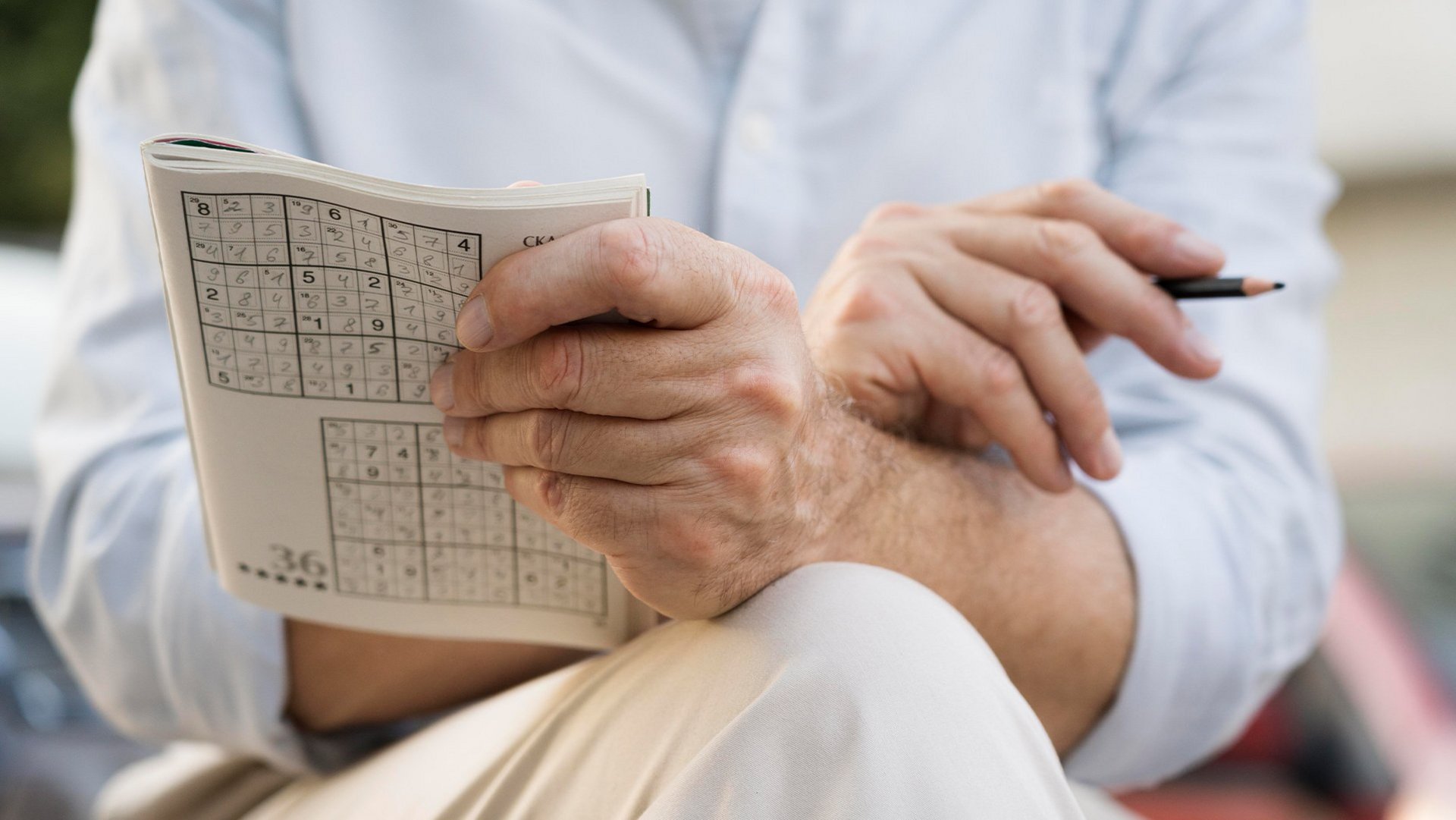 Das Bild zeigt eine Person, welche ein Sudoku Rätsel löst.