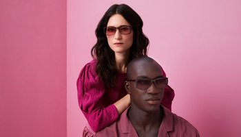 Mann und Frau mit Filterbrille stehen vor einer rosa Wand 