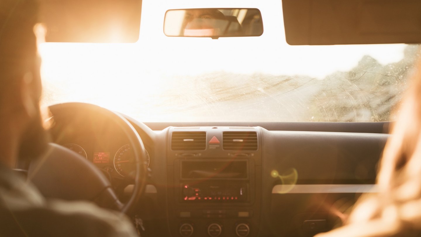 Das Foto zeigt zwei Personen in einem Auto bei starker Blendung.