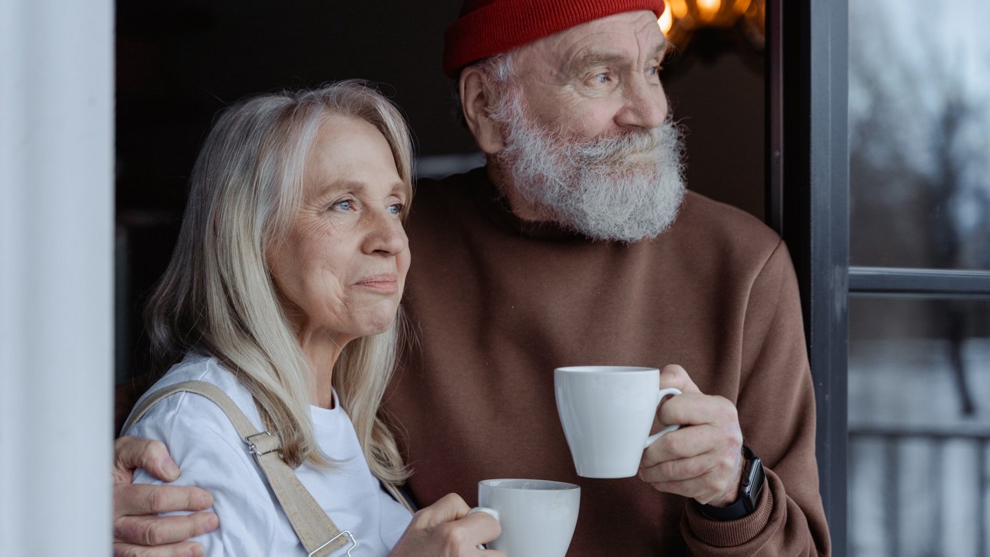 Das Bild zeigt ein älteres Paar mit Kaffeetassen.