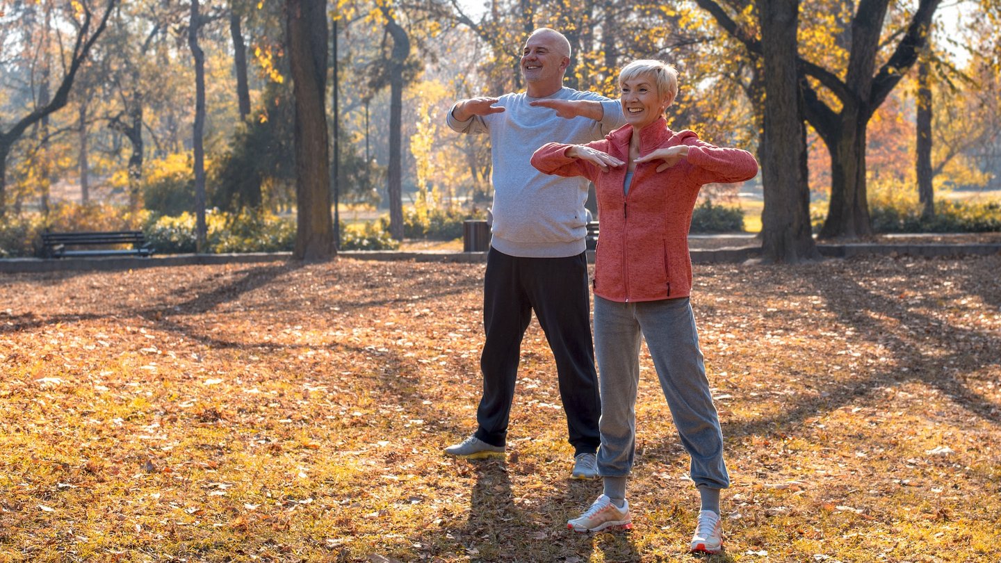 Das Bild zeigt zwei Menschen beim Sport im Park.