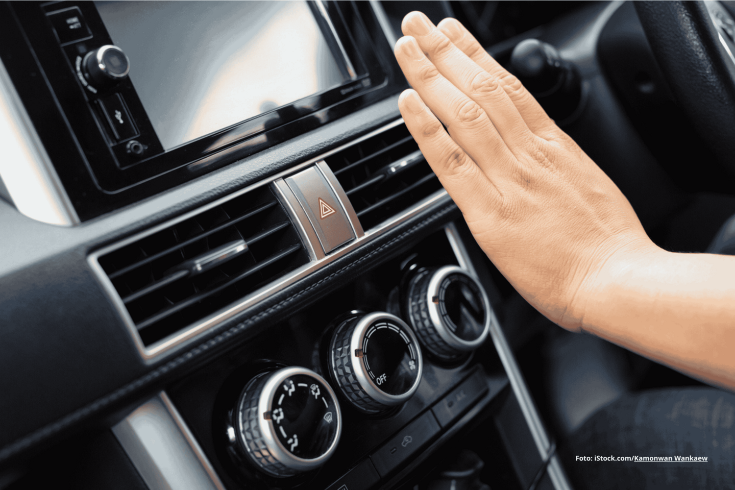 Das Foto zeigt eine Klimaanlage im Auto und eine Person, die ihre Hand davor hält.