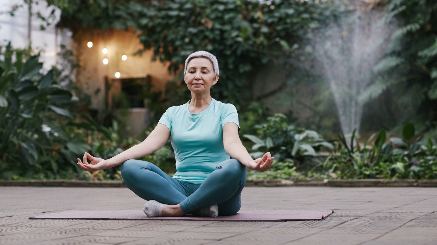Das Bild zeigt eine Frau beim Meditieren.