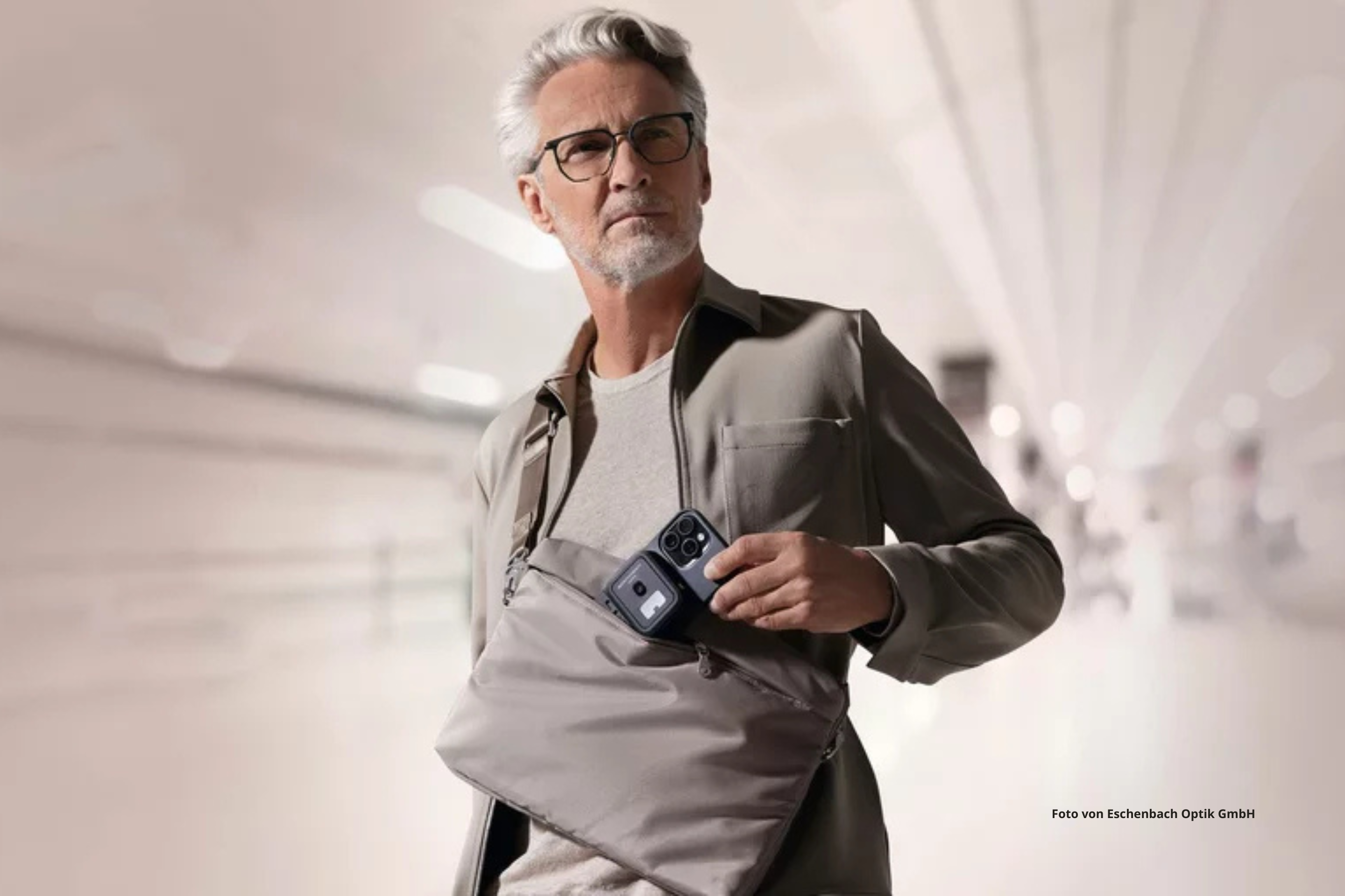 Ein Mann zieht sein optaro aus der Tasche. 