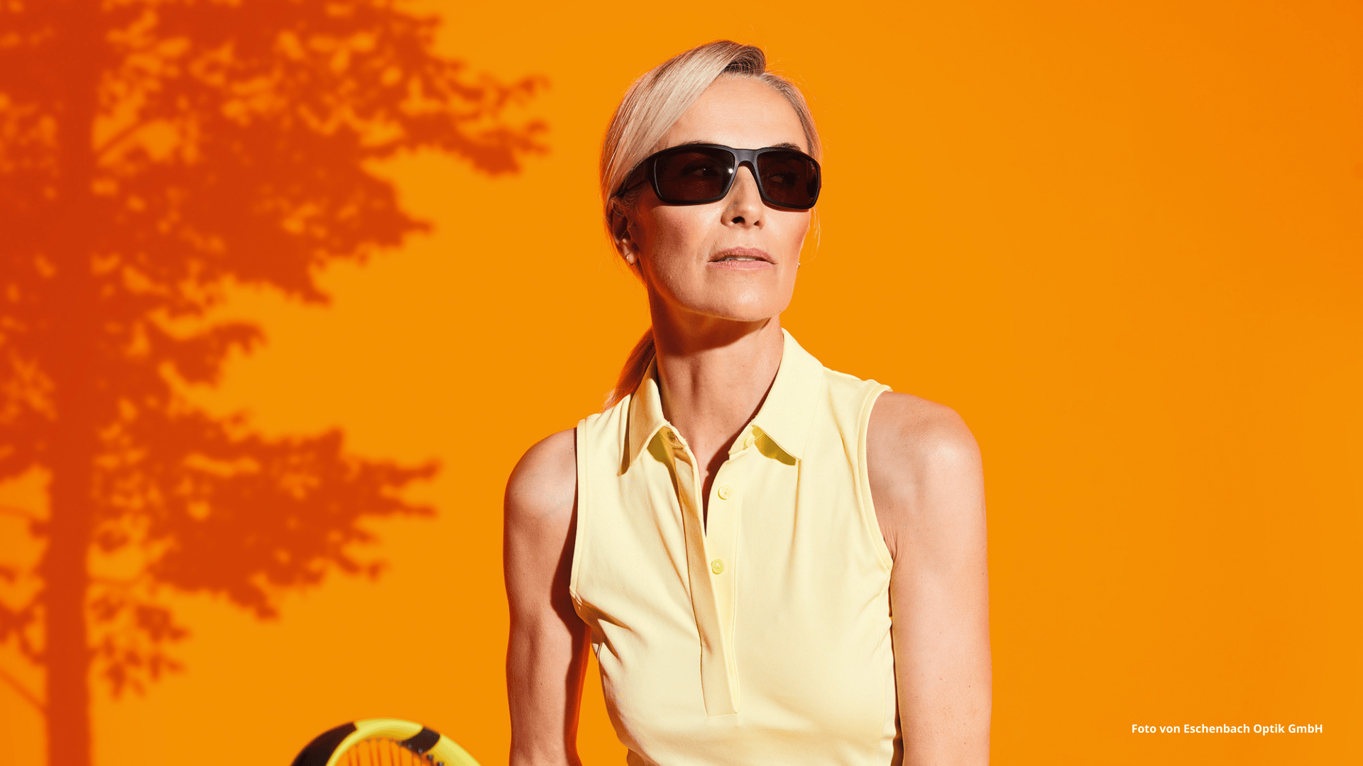 Das Foto zeigt eine Frau, die die ambelis® Sportfassung beim Tennis spielen trägt. 