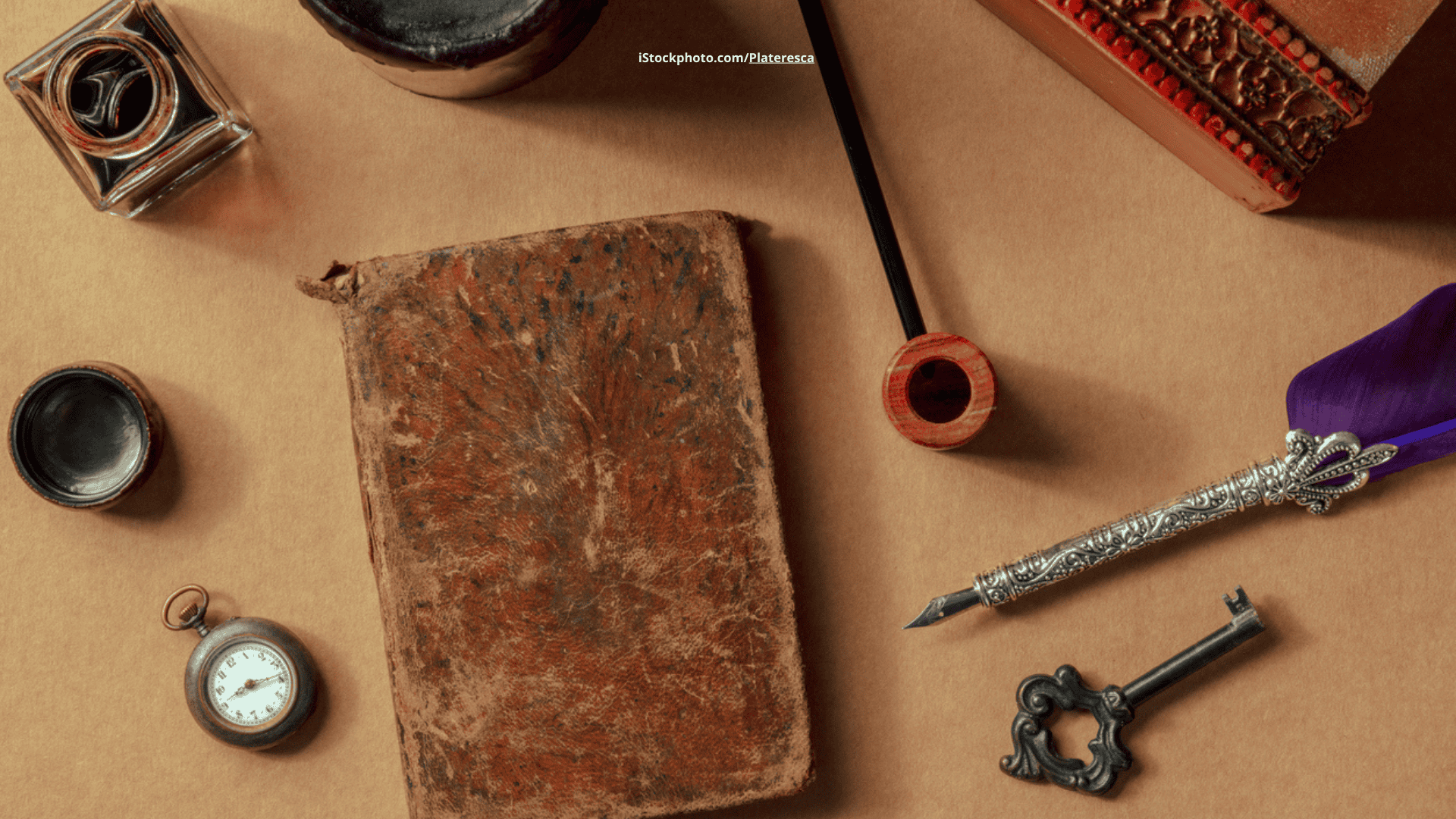 Das Foto zeigt Detektivzubehör auf einem braunen Tisch liegend.